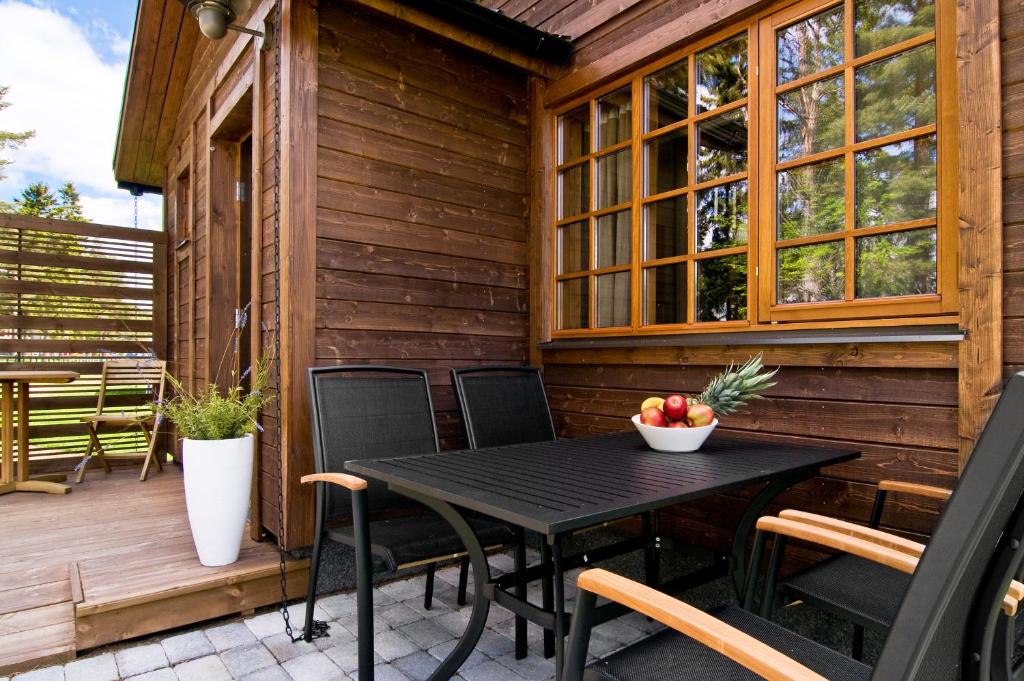 einen schwarzen Tisch und Stühle auf einer Holzterrasse in der Unterkunft Årsunda Strandbad in Årsunda