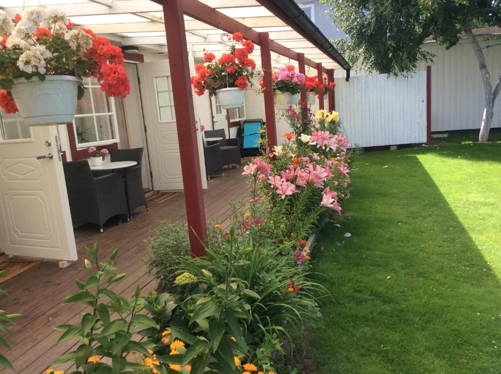 a covered patio with flowers in a yard at Kalkstenens Bed and Breakfast in Mörbylånga