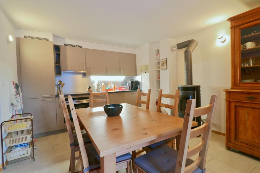cocina con mesa de madera y algunas sillas en Beautiful apartment in the Mayens de Sion, 500m from the Ours piste - 4 Vallées, en Agettes