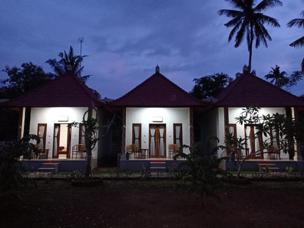 une maison éclairée la nuit dans l'établissement Santhi Guna Bungalow, à Nusa Penida