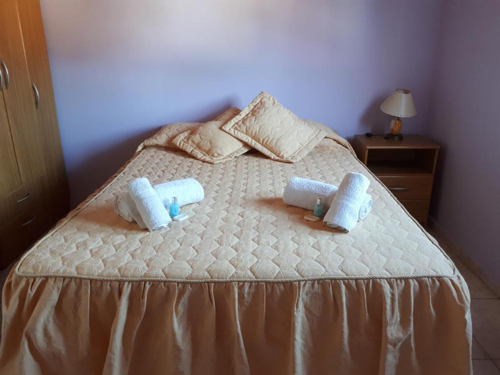 1 dormitorio con 1 cama con 2 toallas en Departamentos San Expedito en Malargüe