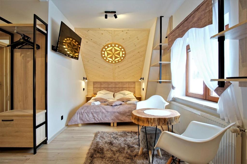 a bedroom with a bed and a table and chairs at U Janiny in Bukowina Tatrzańska