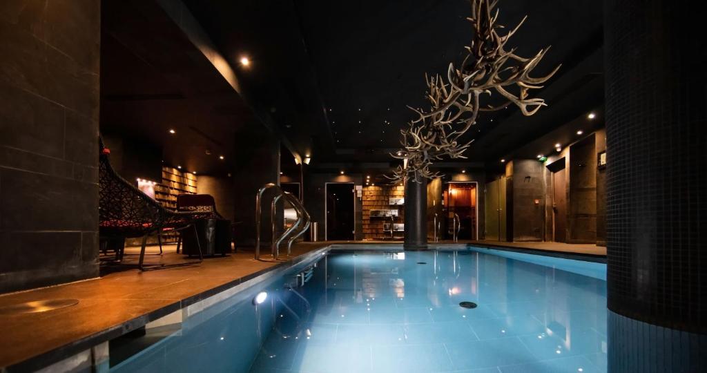 a swimming pool with a christmas tree in a building at Avenue Lodge Hotel & Spa in Val dʼIsère