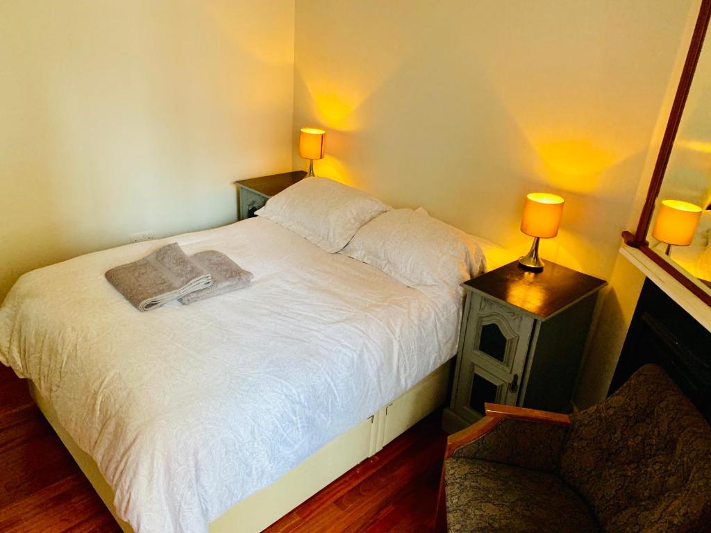 ロンドンにあるTapestry Apartmentのベッドルーム1室(白いベッド1台、ランプ2つ付)