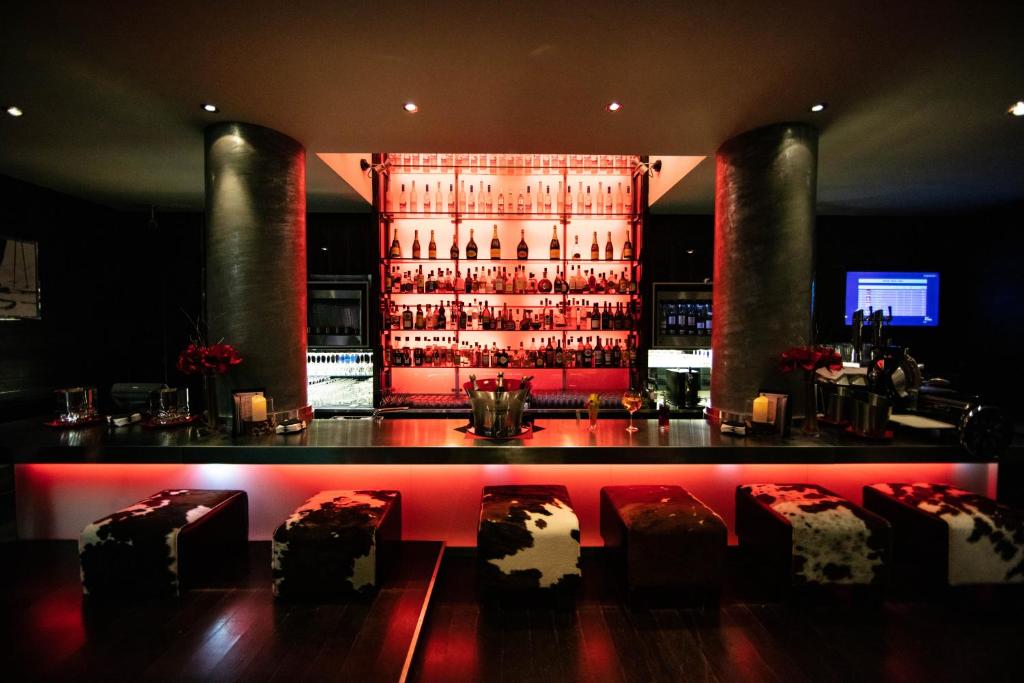 a bar with red lights in a room at Avenue Lodge Hotel & Spa in Val-d'Isère