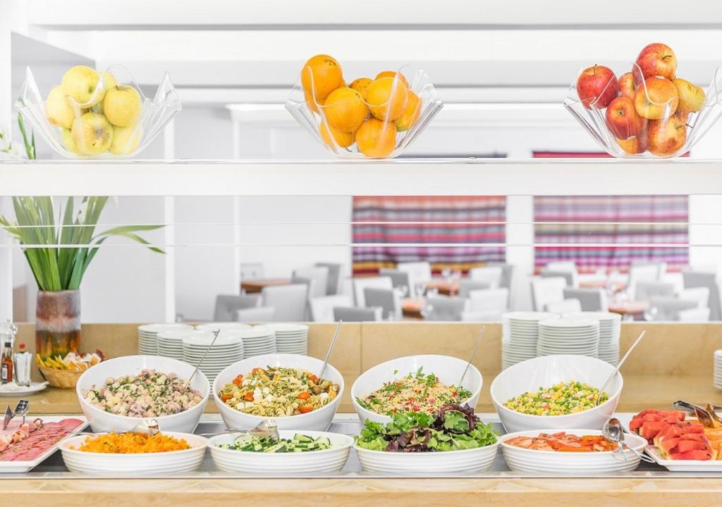 a buffet with bowls of food and plates of food at Hotel Londres Estoril / Cascais in Estoril