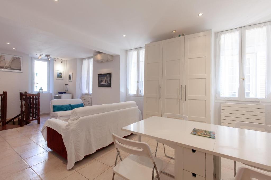 - un salon avec des armoires blanches, une table et des chaises dans l'établissement Saint-Antoine Sea Cannes, à Cannes
