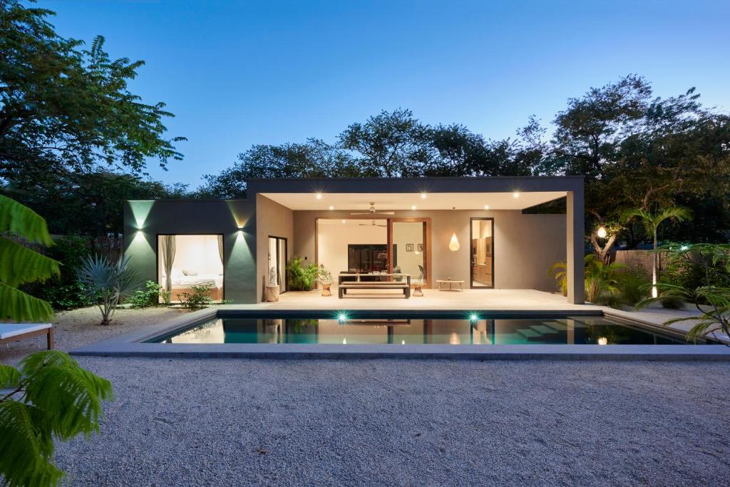 a house with a swimming pool in the backyard at Villa Ethir in Tamarindo