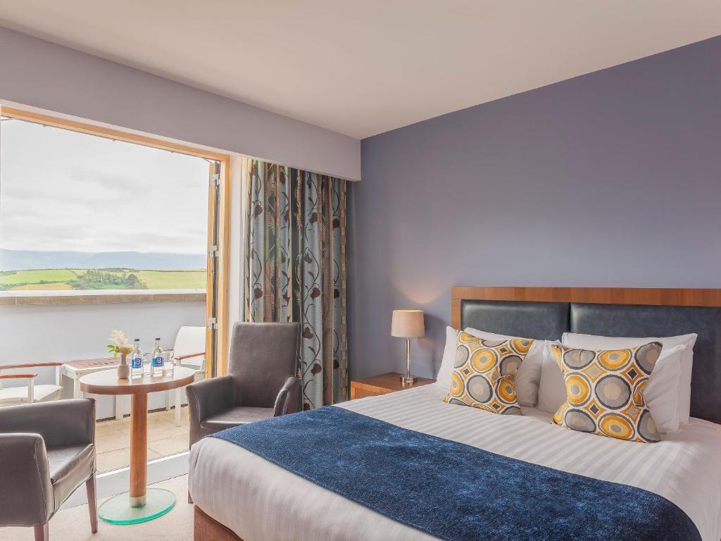 um quarto de hotel com uma cama e uma grande janela em Ballyroe Heights Hotel em Tralee