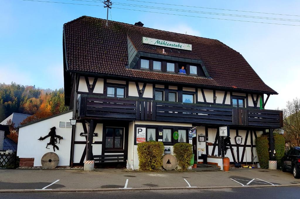 a black and white building with a person in the window at Gasthaus Mühlenstube in Lauterbach