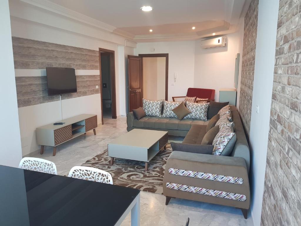- un salon avec deux canapés et une télévision dans l'établissement Luxury Apartment at Berges Lac2, à Tunis