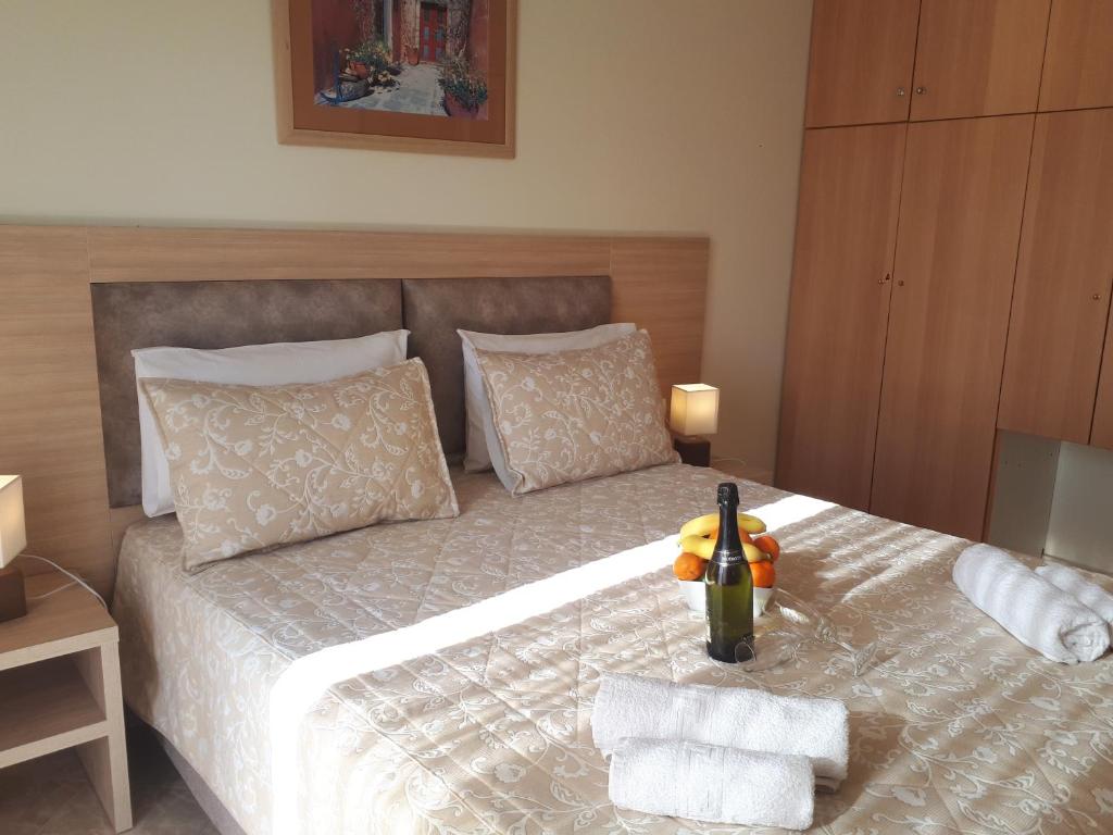 a bedroom with a bed with a bottle of wine on it at Lovely Anna's Apartments in Sarandë