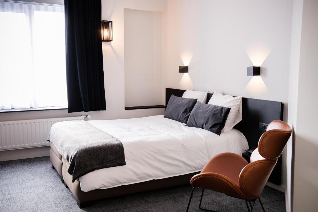 een hotelkamer met een bed en een stoel bij Hotel Carnac in Koksijde