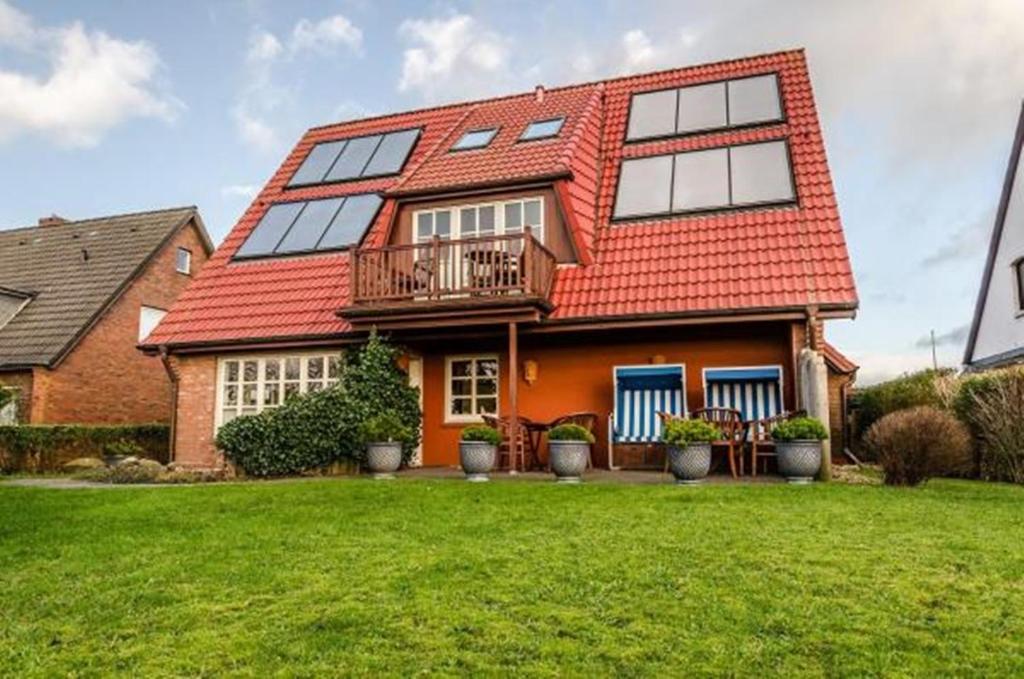 uma casa com um telhado laranja e um quintal em Haus Seelord, Whg. Kapitän em Braderup