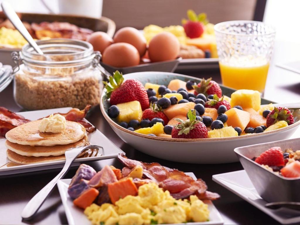 ein Tisch mit Tellern voller Frühstücksspeisen und Getränken in der Unterkunft Hyatt Place Sandestin at Grand Blvd in Destin