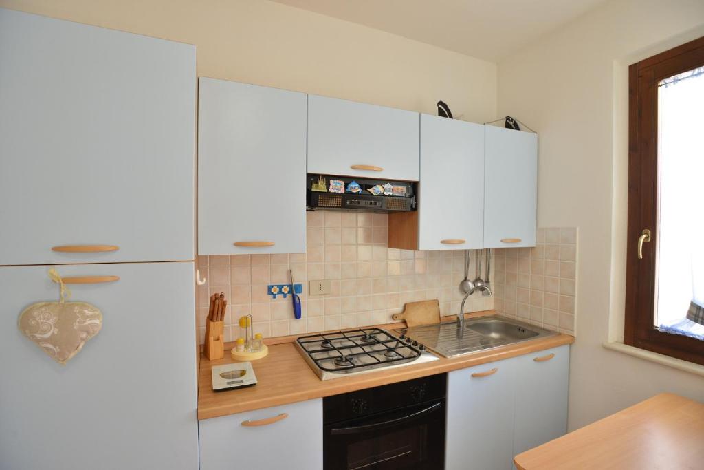 a kitchen with white cabinets and a white refrigerator at IzzHome Crispi in Pula