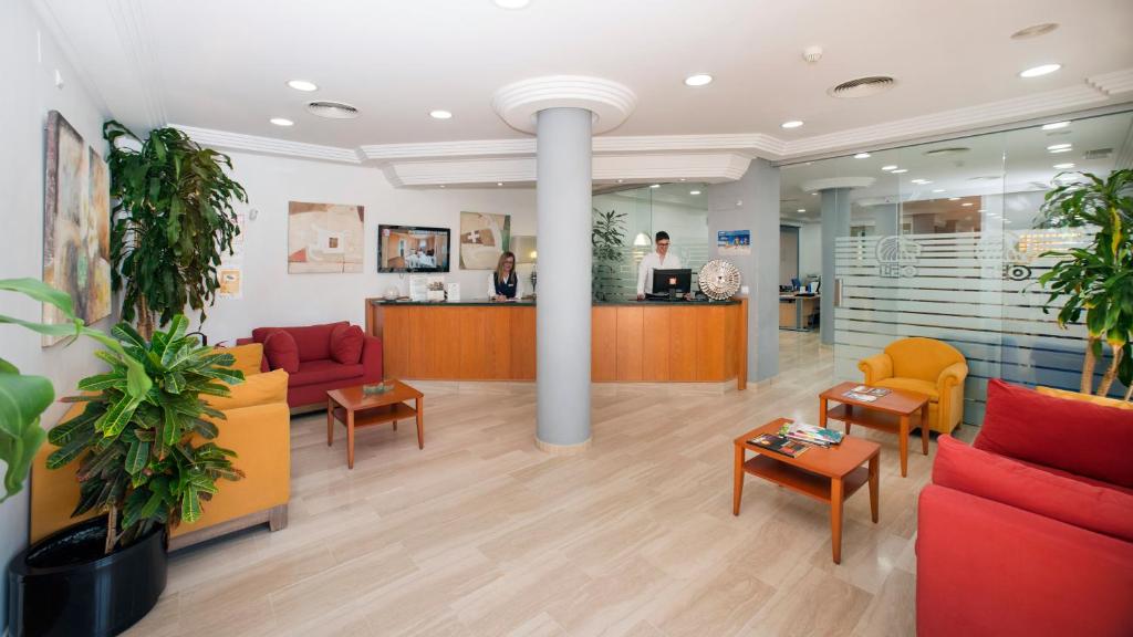 a lobby of a hospital with red and yellow furniture at Leo Canela in Isla Canela