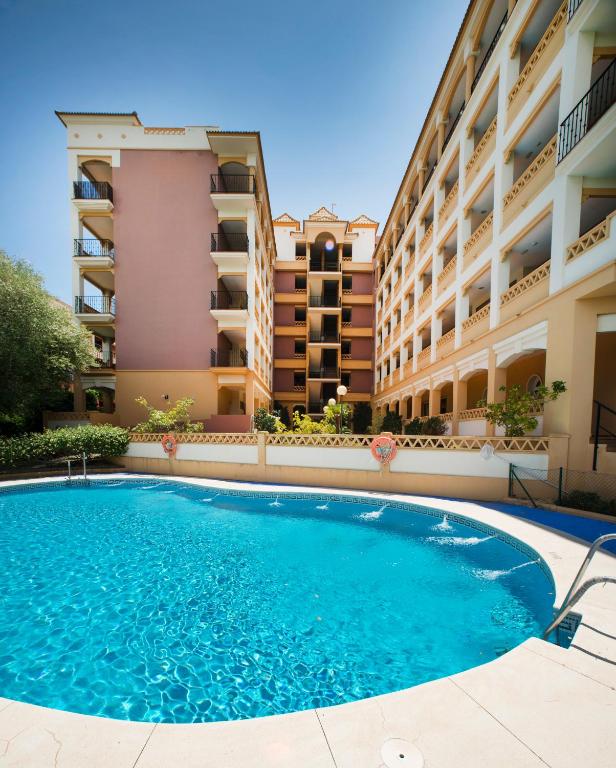 a swimming pool in front of a building at Leo Canela in Isla Canela
