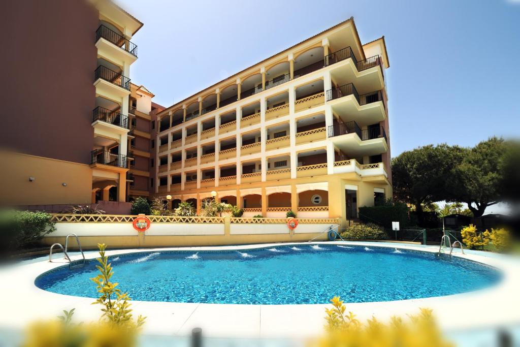 a building with a swimming pool in front of a building at Leo Canela in Isla Canela