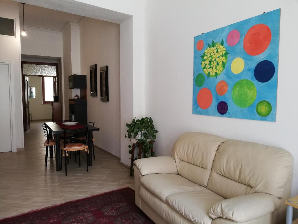 a living room with a couch and a painting on the wall at APPARTAMENTO IN CENTRO in Marsala