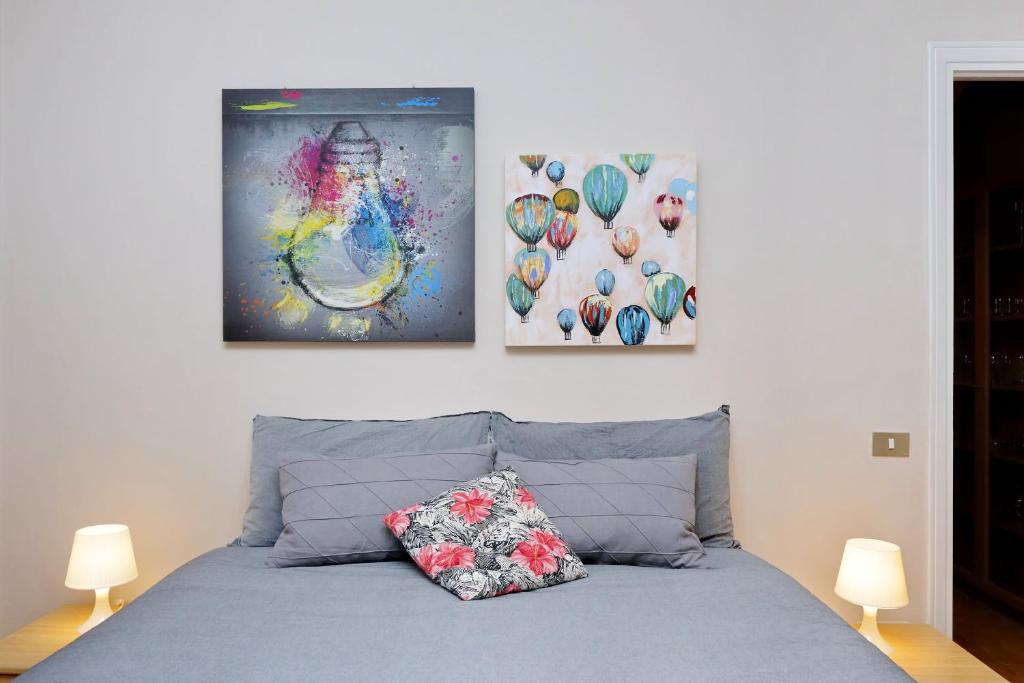 ein Schlafzimmer mit zwei Gemälden an der Wand und einem Bett in der Unterkunft Aldo's Place in Rom