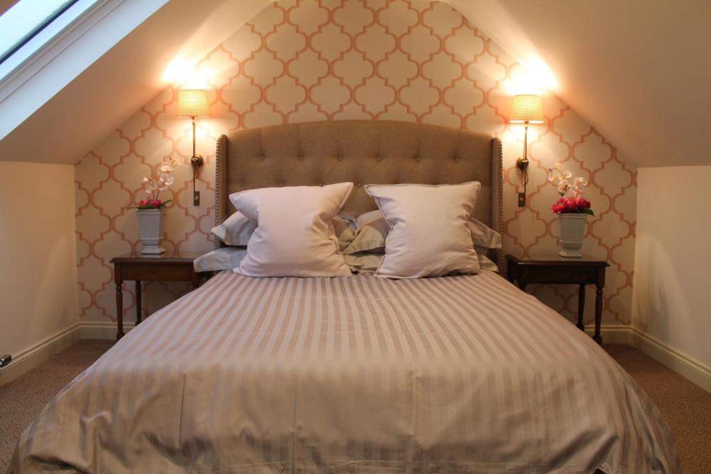 a bedroom with a large bed with two night stands at Granny's Attic at Cliff House Farm Holiday Cottages, in Whitby
