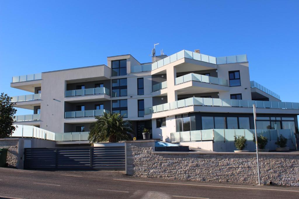 a white apartment building on the side of a street at Apartmani Uwe in Banjole