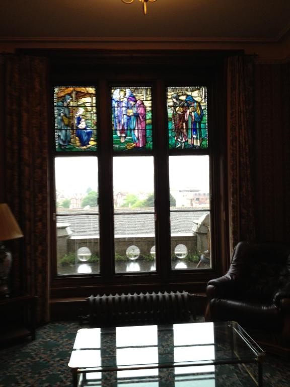 a living room with a window with stained glass at Purbeck House Hotel & Louisa Lodge in Swanage