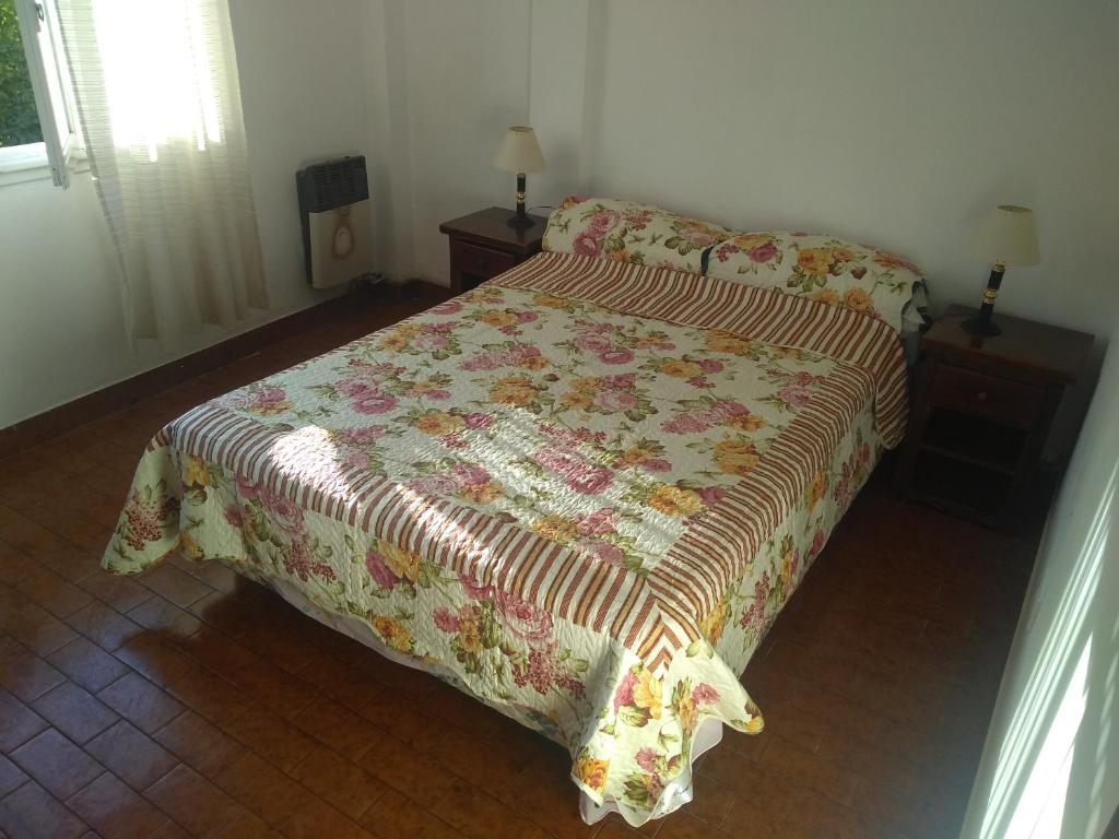 Un dormitorio con una cama con una manta. en Departamento Flores del mar en San Clemente del Tuyú