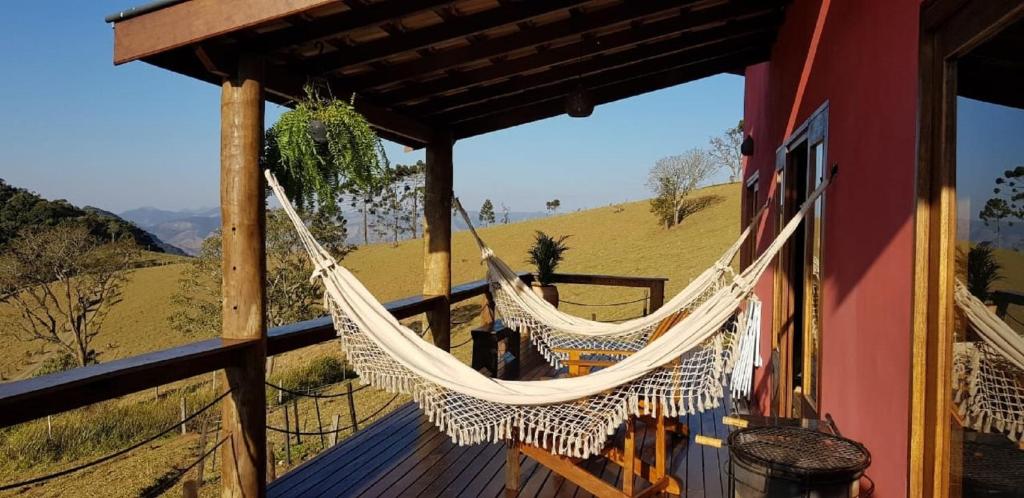 a hammock on the porch of a house with a view at Casa Vista da Lagoa in Gonçalves