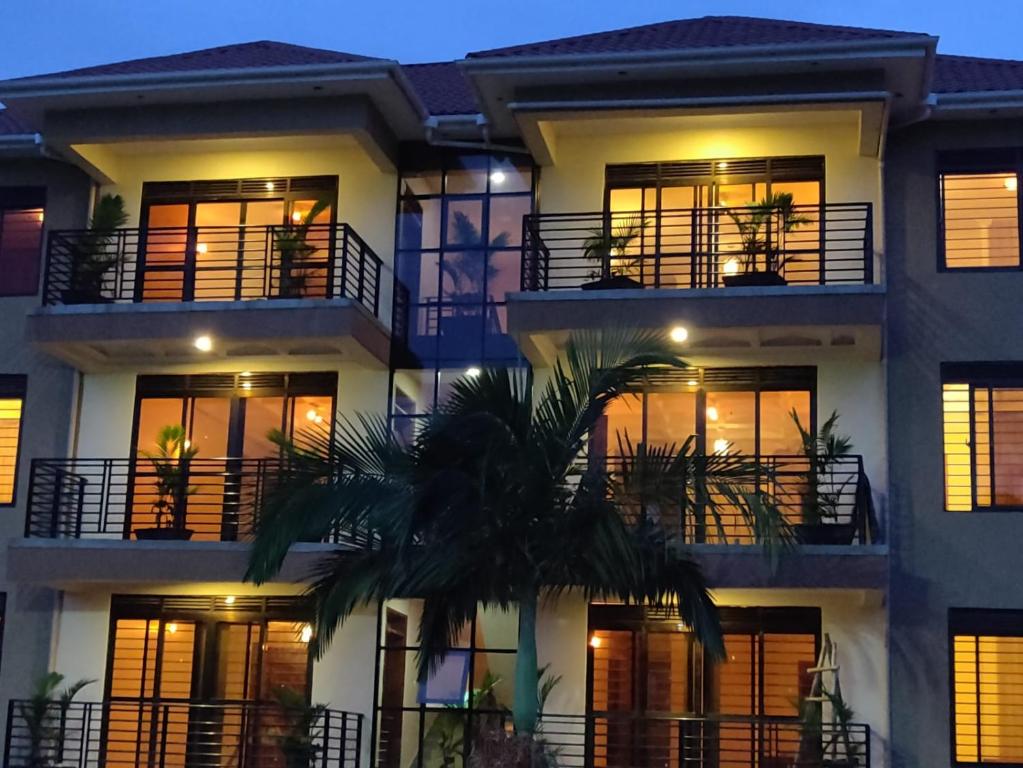 um edifício com uma palmeira em frente em Kampala Suburbs Apartment em Kampala