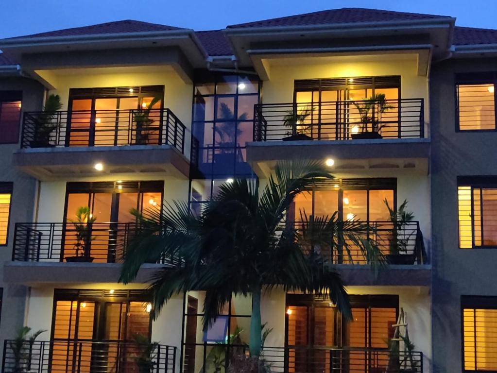 a building with a palm tree in front of it at Kampala Suburbs Apartment in Kampala