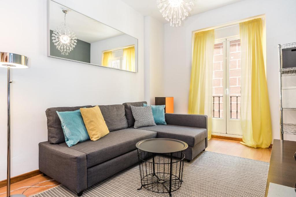 a living room with a couch and a table at Waou Gran Via I - Alquiler Corta Duración in Madrid