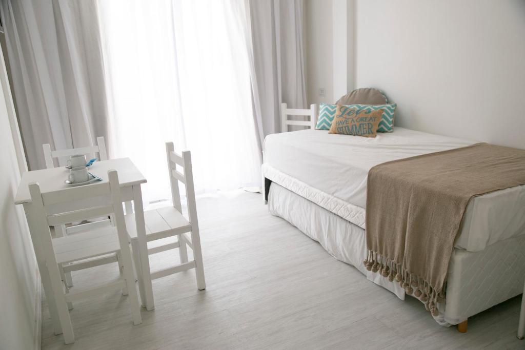 a bedroom with a bed and a table and chairs at Hotel del Mar in Valeria del Mar