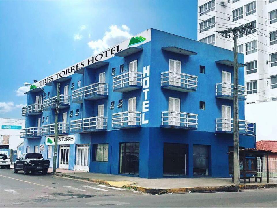 a blue building on the corner of a street at TRES TORRES POUSADA in Torres