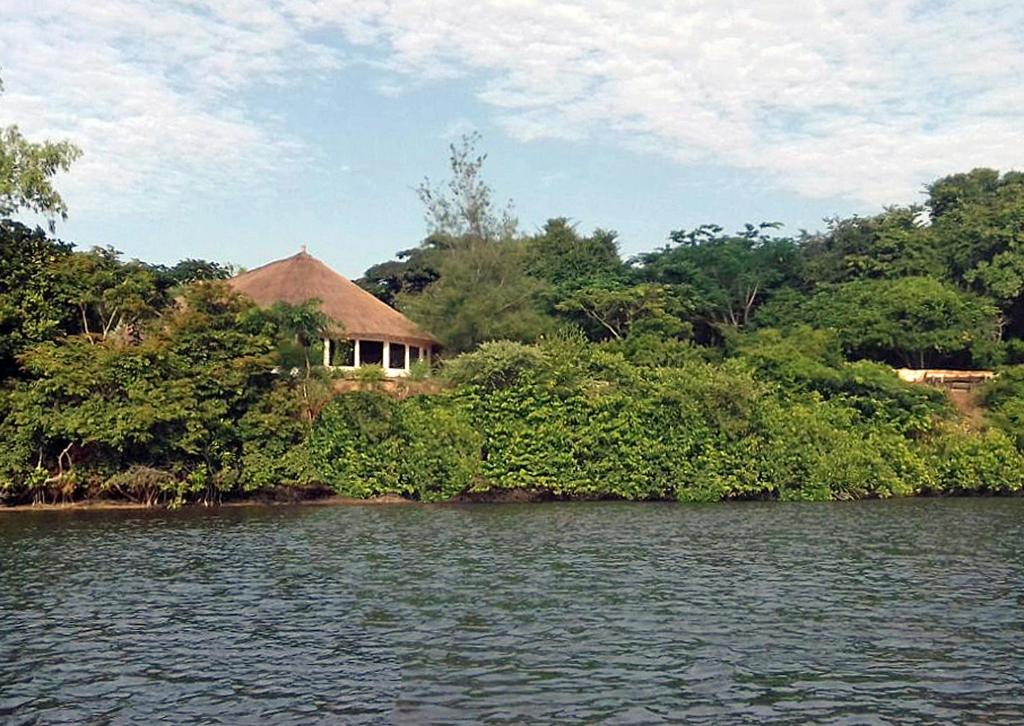 a house on the shore of a body of water at Campement île d'Egueye in Diakène Ouolof