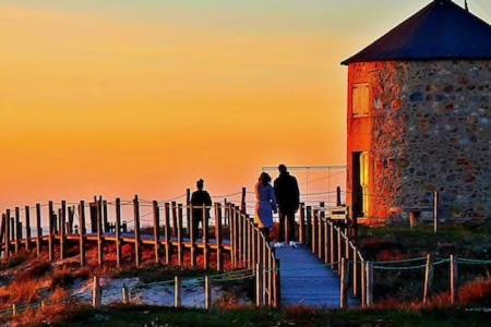 un gruppo di persone in piedi su un molo vicino a un faro di casa de praia - Studio a Esposende