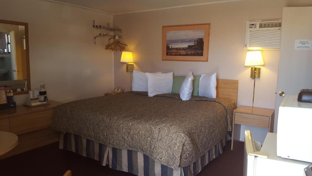 um quarto de hotel com uma cama e duas lâmpadas em Cozy Inn em Cortez