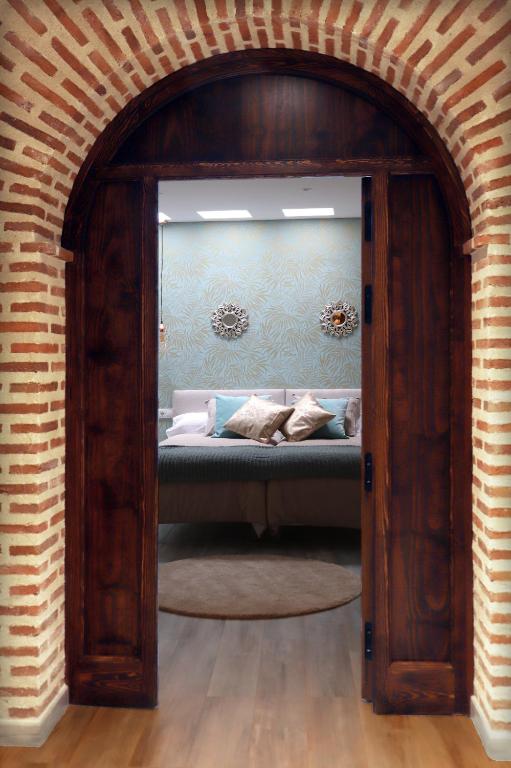 a room with a couch in a room with a brick wall at Apartamentos turísticos Desiree in Arévalo