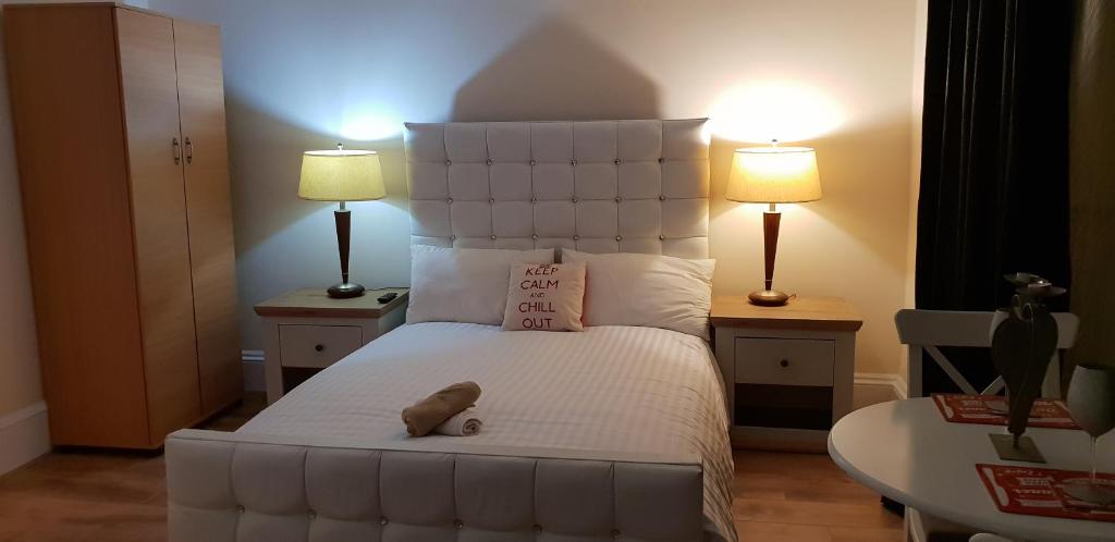 1 dormitorio con 1 cama blanca grande y 2 lámparas en Strathbungo Studios, en Glasgow