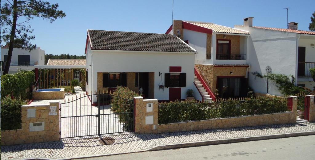 uma casa branca com uma cerca à frente. em Casa da LAGOA (Sesimbra) em Lagoa de Albufeira