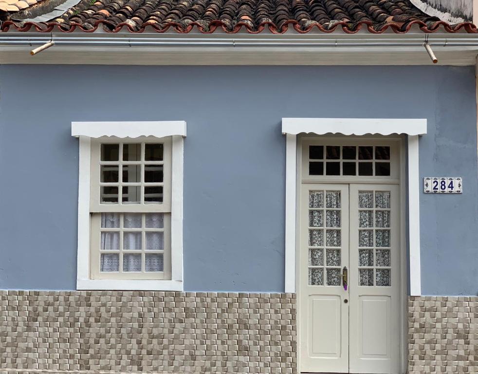 a blue house with two windows and a door at Casa Centro Histórico in São João del Rei