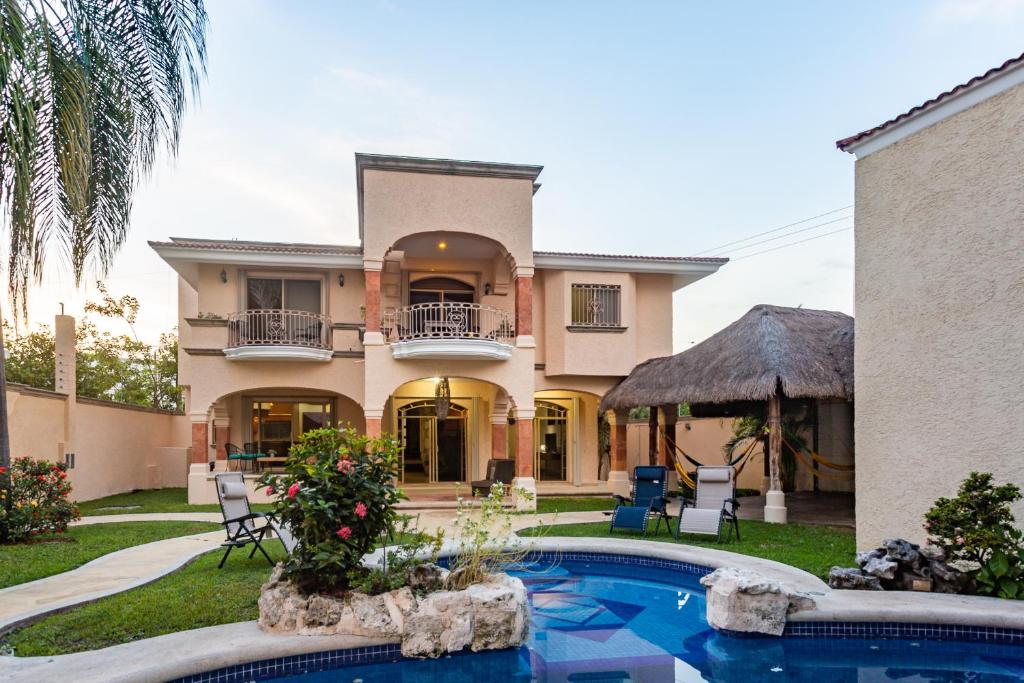 a house with a swimming pool in front of it at Casa Frida Cozumel in Cozumel