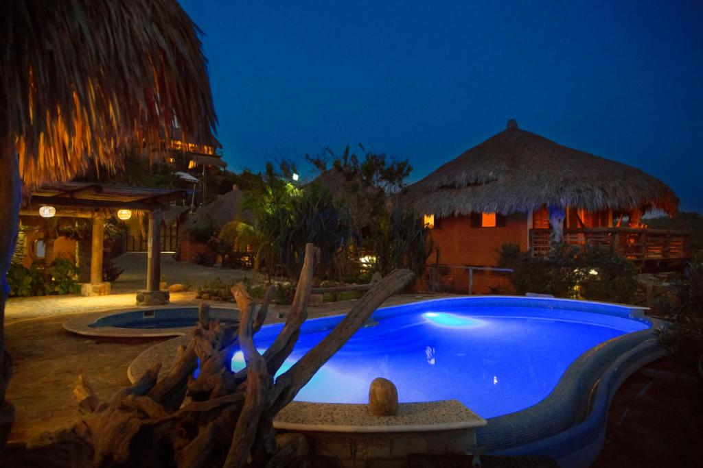 a swimming pool in a resort at night at Cabañas Las 3 Marias in San Agustinillo