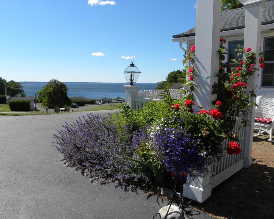 a house with flowers on the side of it at Colonial Gables Oceanfront Village in Belfast