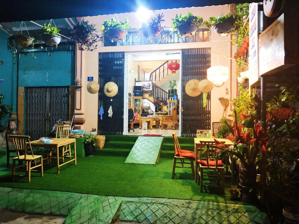 um quarto com cadeiras e mesas e um tapete verde em Cao Bang Eco Homestay em Cao Bang