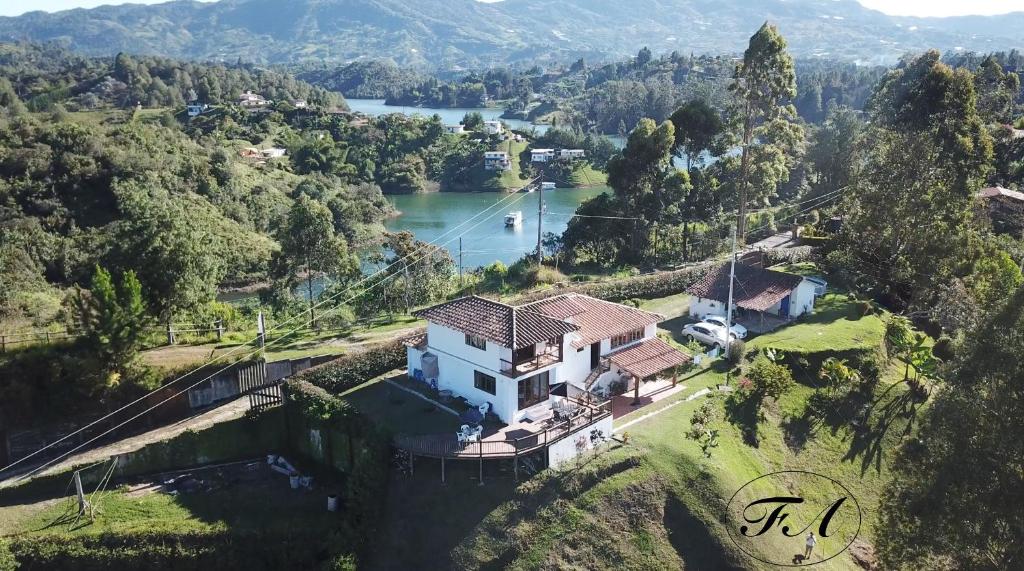 eine Luftansicht eines Hauses auf einem Hügel neben einem See in der Unterkunft Finca Alejandria in Guatapé