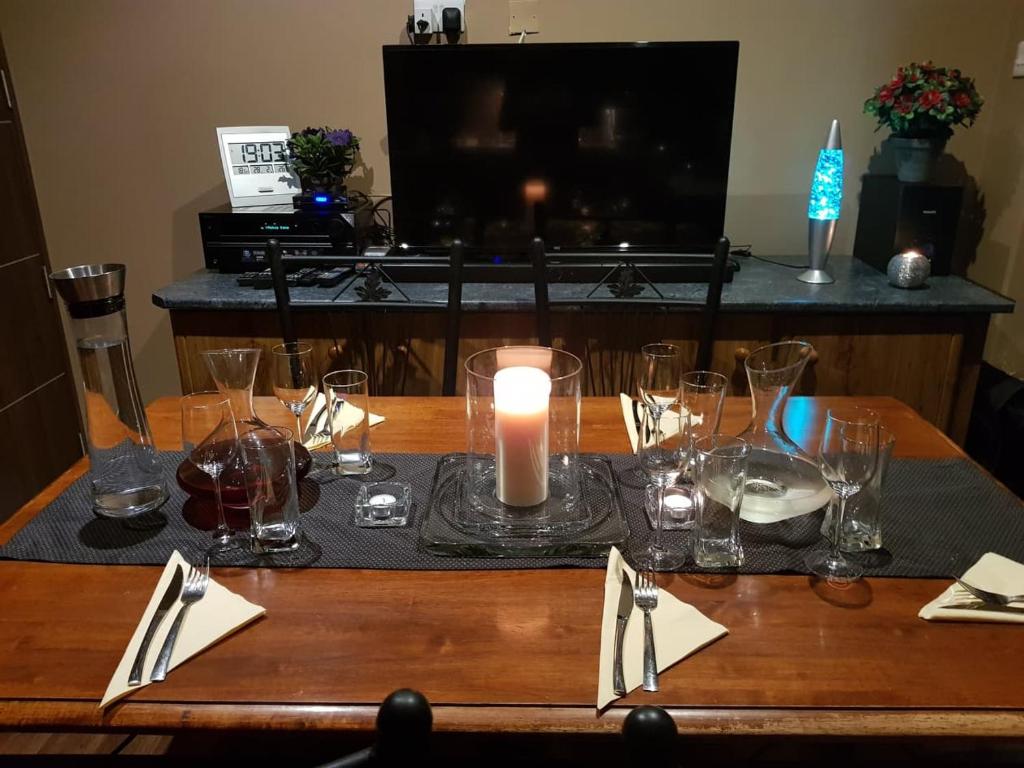 a table with a candle and glasses on it at Lotus Guest House Malta in Il-Gżira