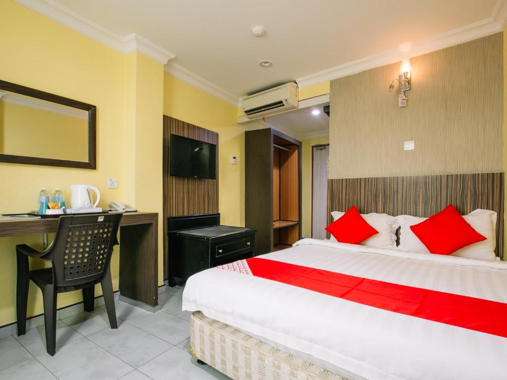 a hotel room with a large bed and a desk at Rayyan Soffea Hotel in Kota Bharu