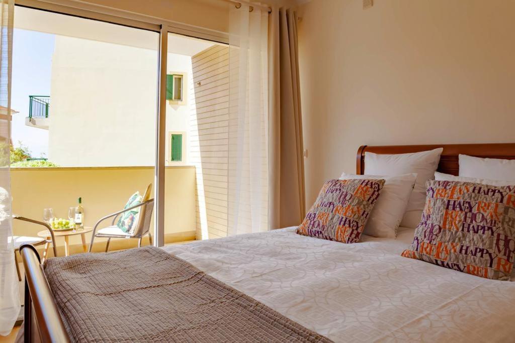 1 dormitorio con 1 cama con ventana y silla en Apartment Formosa - Infinity pool, en Funchal